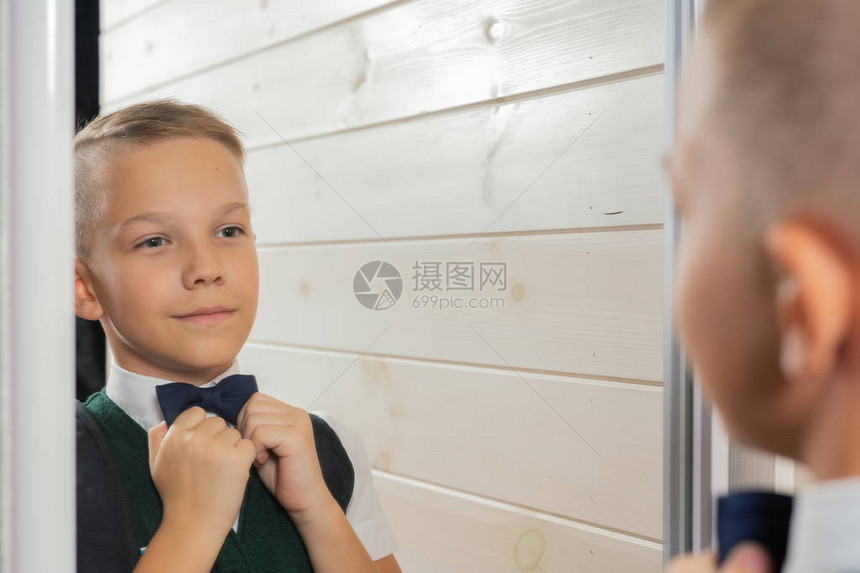 一个10岁男孩在暑假过后准备上学回到学校当着镜子的图片