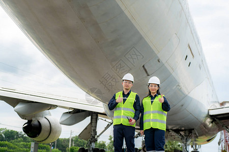 亚洲男女工程师维修飞机竖起大拇指图片