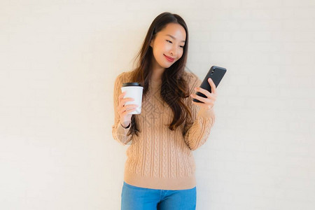 肖像美丽的亚洲年轻女微笑快乐地使用智能手机图片