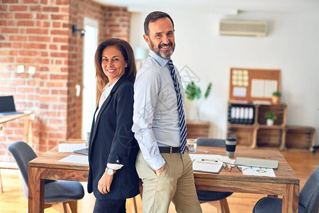 两名中年商业工人在办公室开会时站在一起工作图片