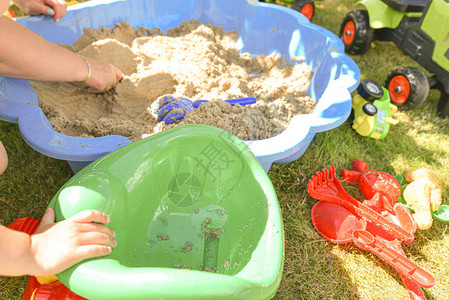 儿童男孩与母亲一起在建筑行业的沙操场桶里玩建筑业图片