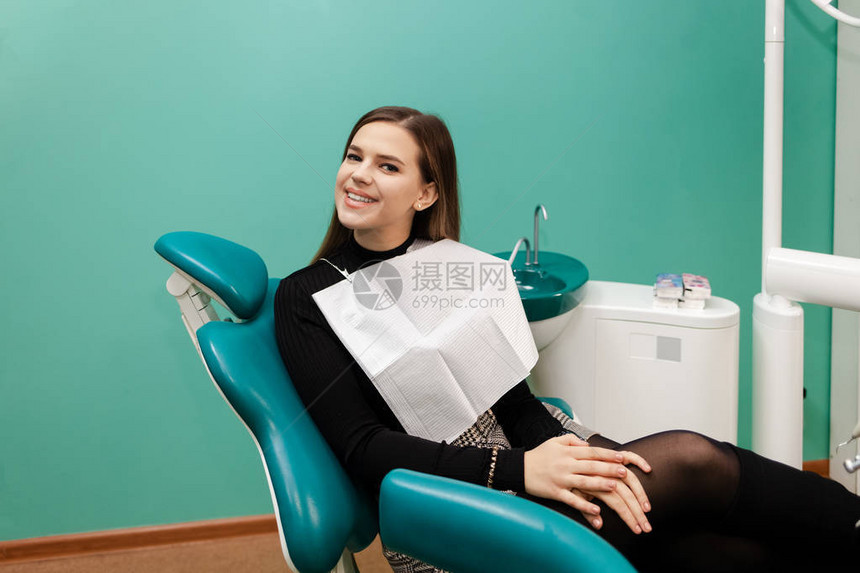 坐在牙科椅上的满意患者图片