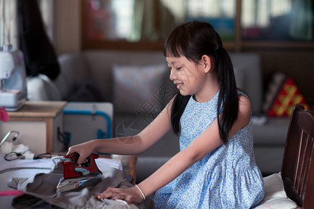 亚裔小女孩坐在屋子里用微笑和快图片