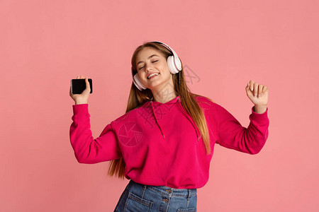 女青少年与无线耳机和智能手机图片