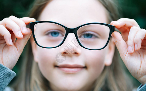 近视矫正眼镜的小女孩的特写肖像图片