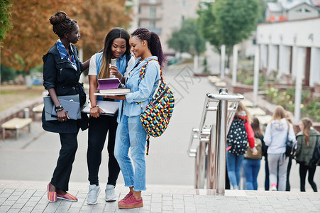 3名非洲女学生在大学院子里背着包和学校用品图片