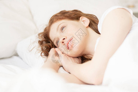 清晨醒来后躺在枕头上带着长松黄姜头发的快乐图片