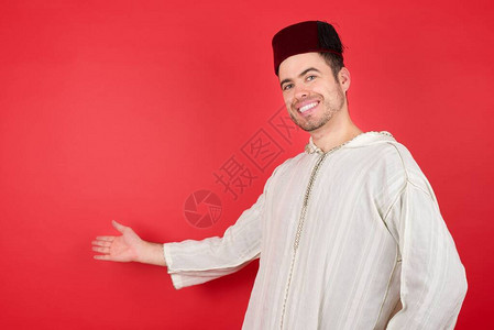 年轻英俊的年轻人穿着fez感到快乐和开朗背景图片