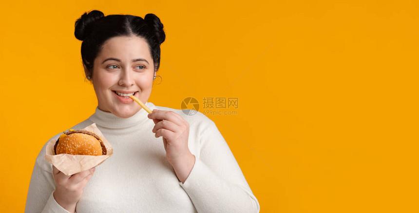 布朗特胖子女孩吃着美味的汉堡包和薯条图片