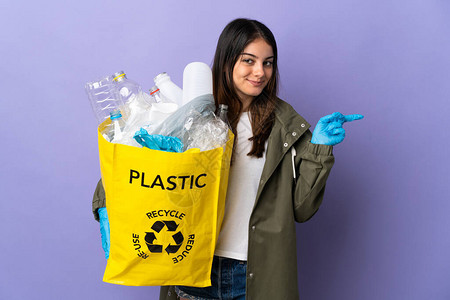 年轻女子拿着一袋装满塑料瓶的塑料瓶图片