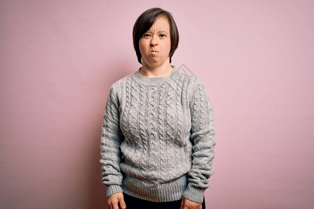 年轻的唐氏综合症妇女在孤立的背景下穿着休闲毛衣图片