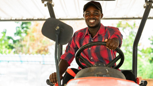 非洲农民在农村收获期间在农场驾驶拖拉机农图片