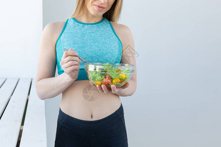 健康健身人的概念饮食沙拉和运动服的女人图片