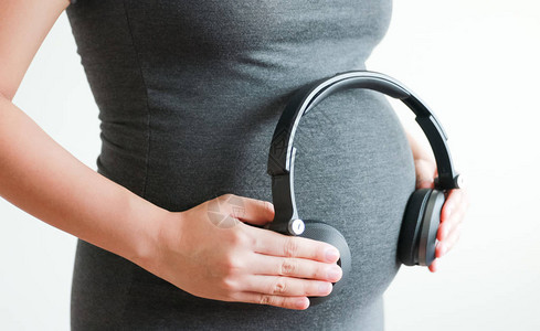 孕妇在肚子上用耳机收图片