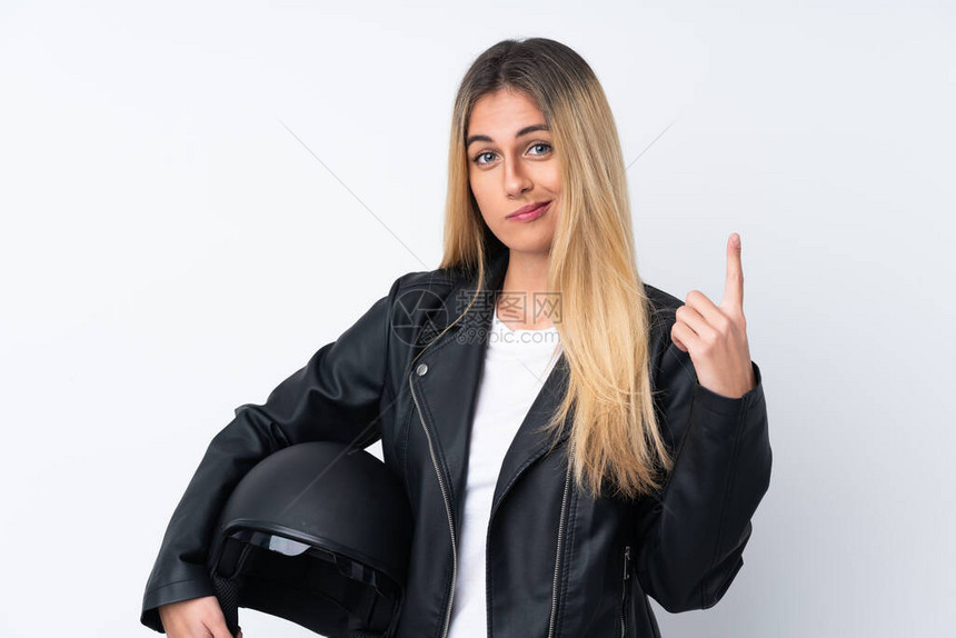 带着摩托头盔的乌拉圭年轻女与孤立的白人背景比对用食指图片