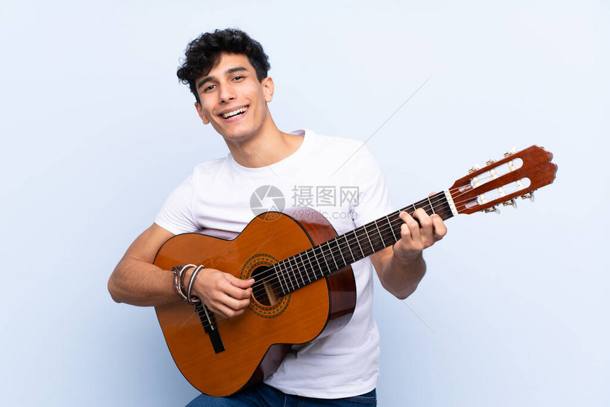 年轻阿根廷男子带着吉他与孤图片