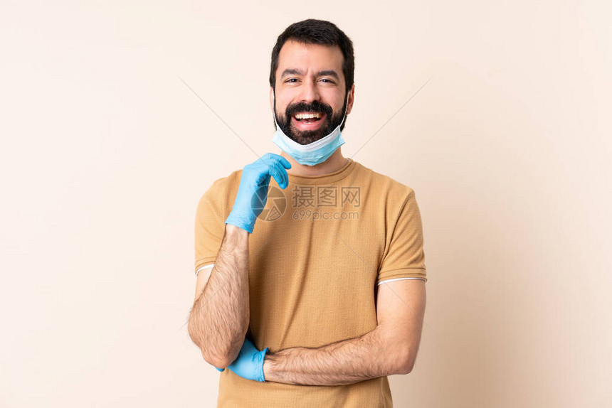 有胡子的白人男子保护免受冠状的伤害戴着面罩和手套在孤图片