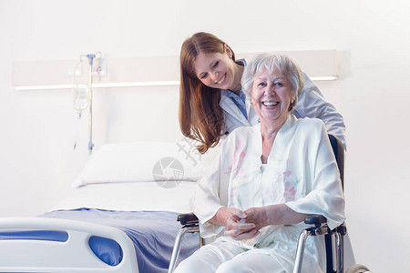 在医院或养老院的轮椅上微笑快乐的老年妇女在受伤或手术康复期间被医图片