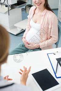 孕妇在诊所咨询妇科医生的剪影图片