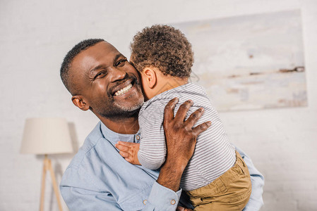 快乐的非裔美国人爷拥抱可爱的小孙子在家里背景图片