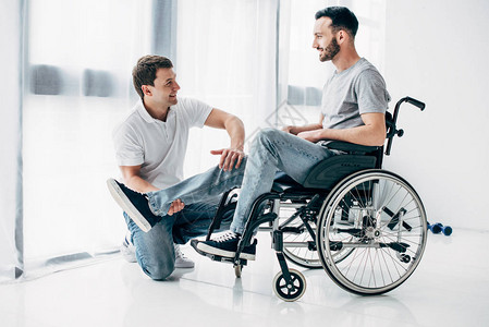 坐在轮椅上的残疾人的腿部按摩手持图片