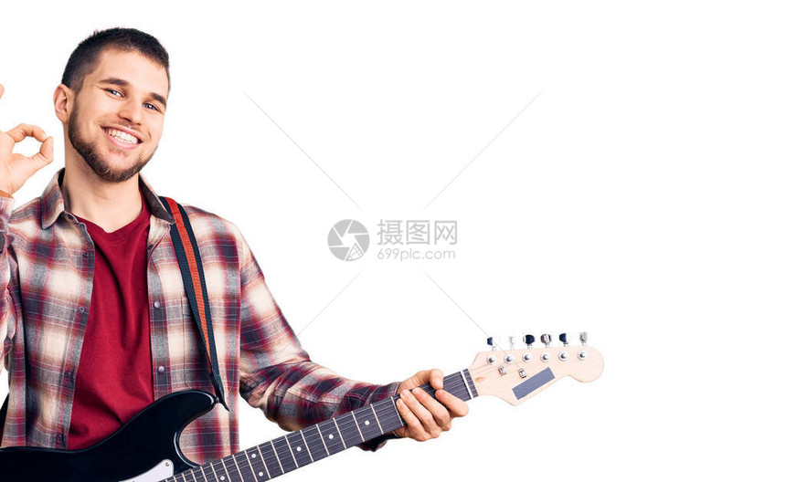 英俊的年轻人弹着电吉他用手指做好标记笑着友善的掌声模图片