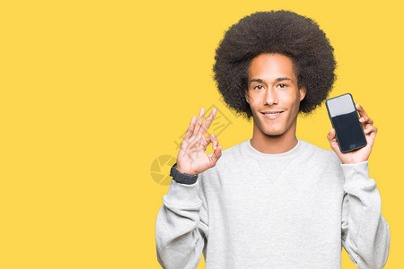 年轻非洲美国人的头发长着假发显示智能手机屏幕用手指做好标记图片
