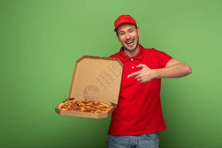 穿着红色制服的快递员指着绿色披萨盒图片