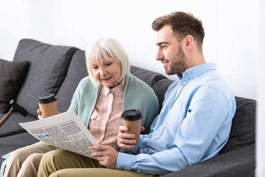 男人和老母亲在家拿着咖啡看报图片