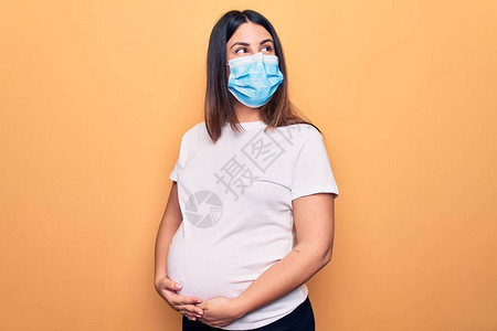 年轻孕妇母亲将带着保护面罩图片