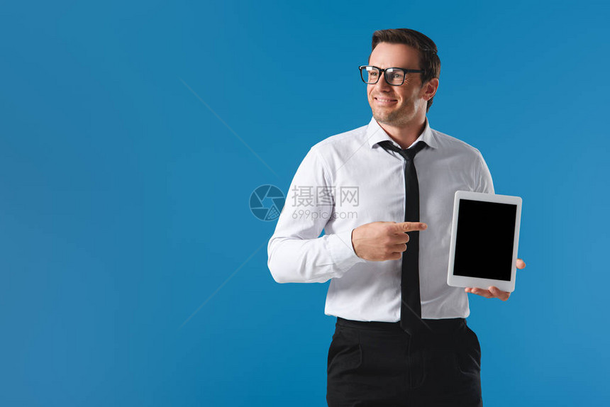 英俊的微笑商人用手指着带有空白屏幕的数字平板电脑图片