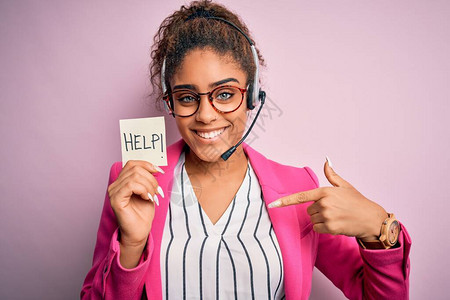 非裔美国人呼叫中心特工女孩使用耳机拿着提示带帮助信息背景图片