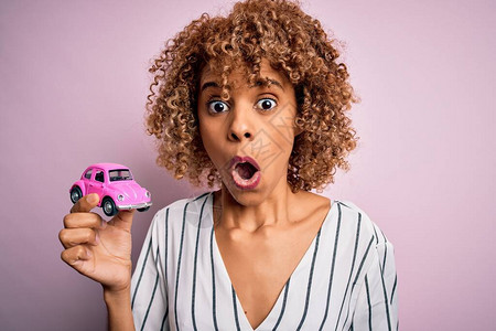 年轻的非洲裔美国女手持粉色小车图片