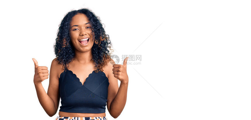 身着散装衣的年轻非洲女成功标志用手大拇指举起微笑和快乐的笑容做出积极姿态图片