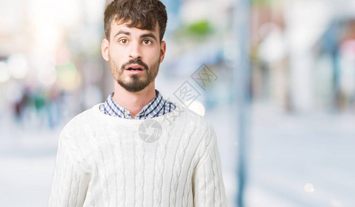 身穿冬毛衣的英俊男青年在孤立的背景中害怕图片