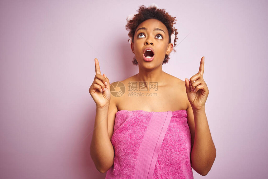 非洲女在粉红色孤立的背景下洗完澡后便穿着浴巾图片