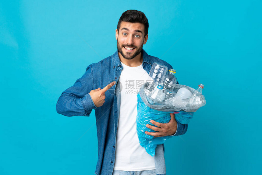 年轻caucasian男子拿着一袋装满塑料瓶的塑料瓶图片