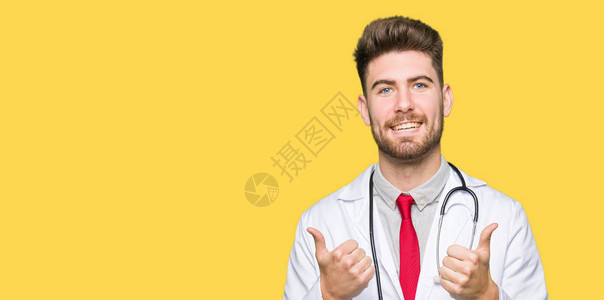 年轻英俊的医生穿着医用外套成功标志用手做积极的手势图片