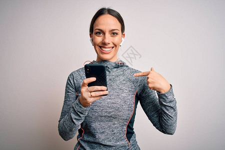 穿着运动服的年轻健身女使用智能手机应用程序图片