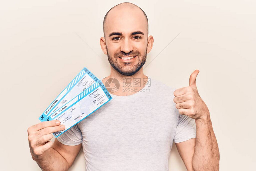 年轻英俊的秃头男子持有航空公司登机证图片