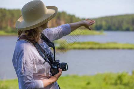 一位老妇人拿着相机为大自然拍照并享受生活老年人生图片