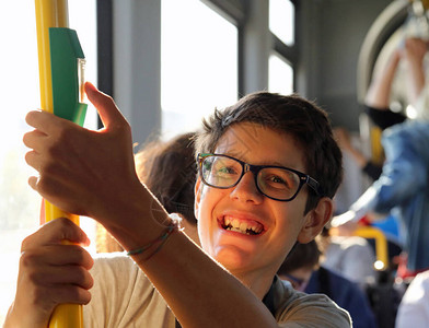 带着时装眼镜的快乐男孩通过电车旅行图片