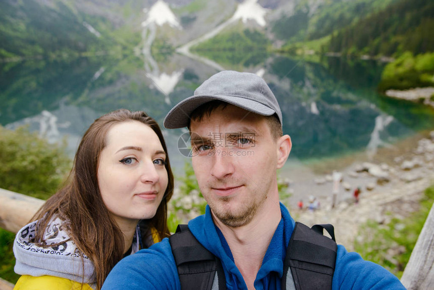 在山上玩自拍的情侣与湖图片