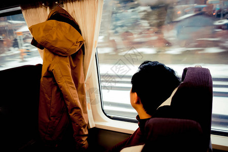 亚洲人透过窗户看雪他在日本北海道乘坐火车旅行冬季北图片