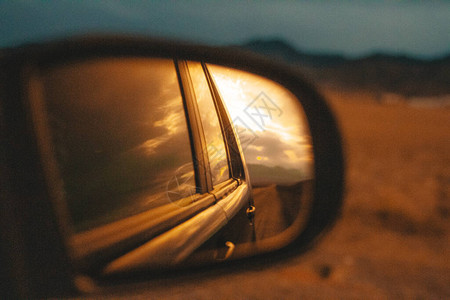 由SUV山路云和日落照镜子反射而成的图片