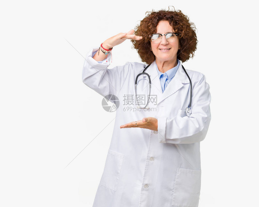 中年高级医生女人在孤立的背景下用双手展示大小的标志图片