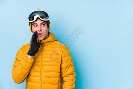 戴着滑雪板护目镜的年轻滑雪者正在说一个秘密的热刹车新闻图片
