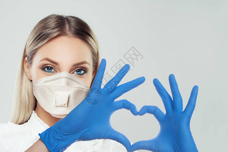 戴着防护面具和医生手套的女人在做心脏医疗保健医图片