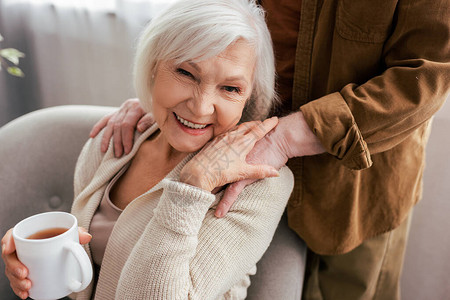男人触摸着快乐的老年妻子肩膀图片
