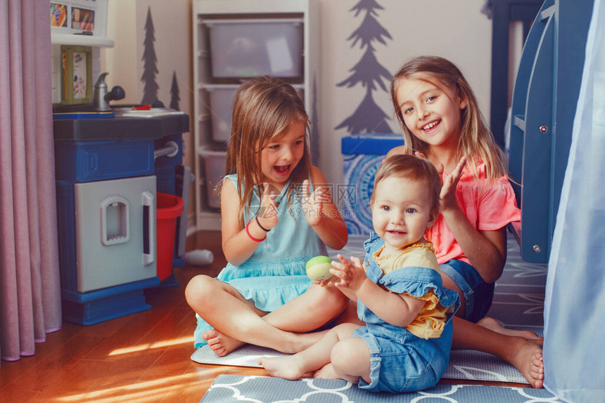 白种人女孩兄弟姐妹坐在家里的地板上和蹒跚学步的妹玩耍快乐的朋友关系概念可爱的孩子们一起玩耍真实坦率的图片